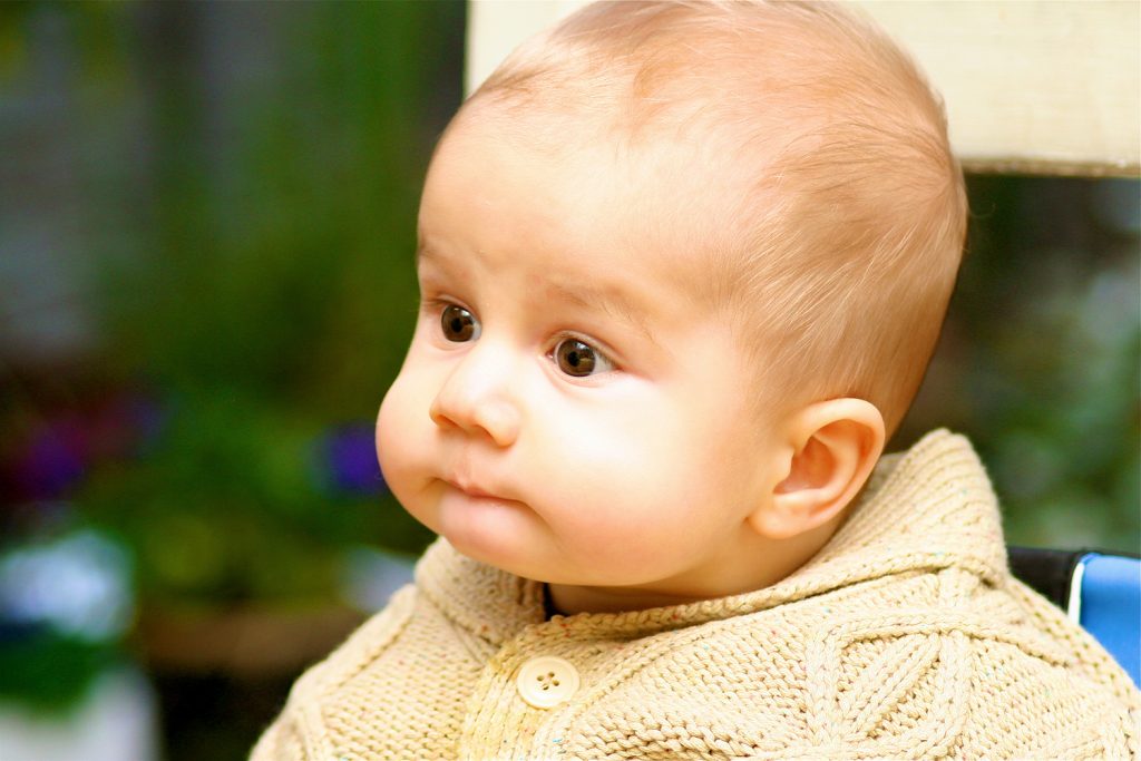 Very cute baby sitting in high chair