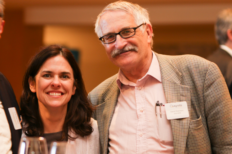 Smiling woman standing with older man in glasses