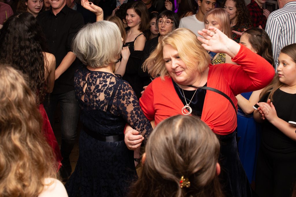Women dancing together spinning at party