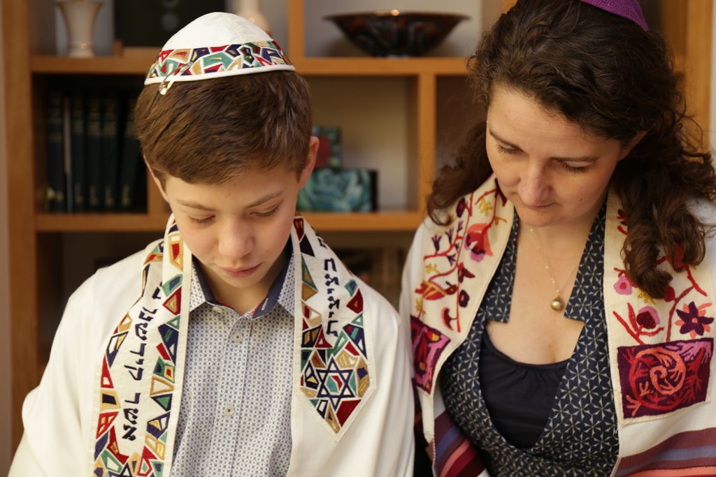 Barmitzvah boy reading with Rabbi