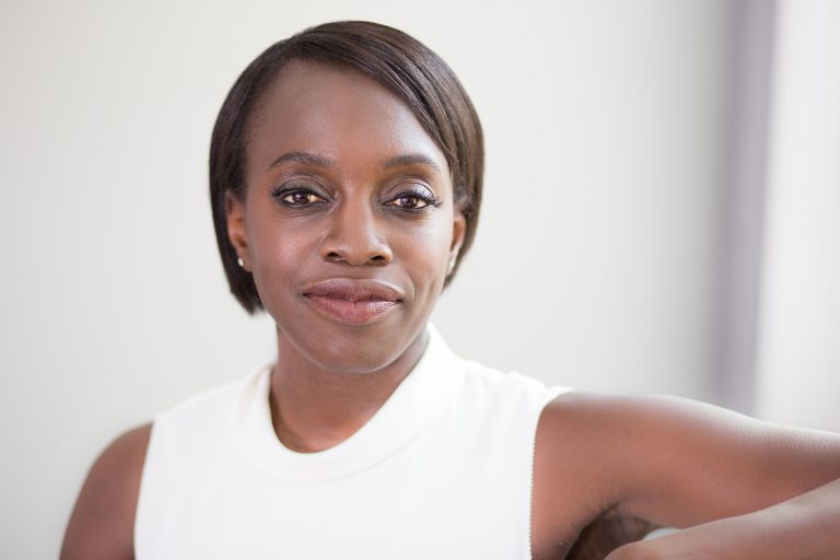 Black woman in white top staring into camera
