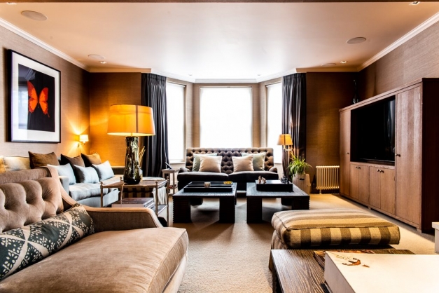 Living room with large brown velvet sofas and wooden coffee tables