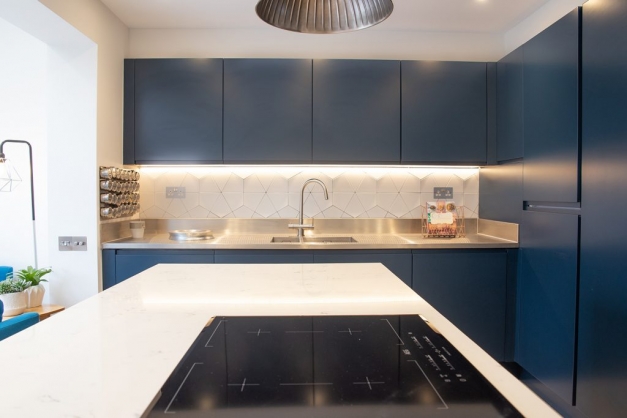 Modern style kitchen with blue cabinets and white work surface