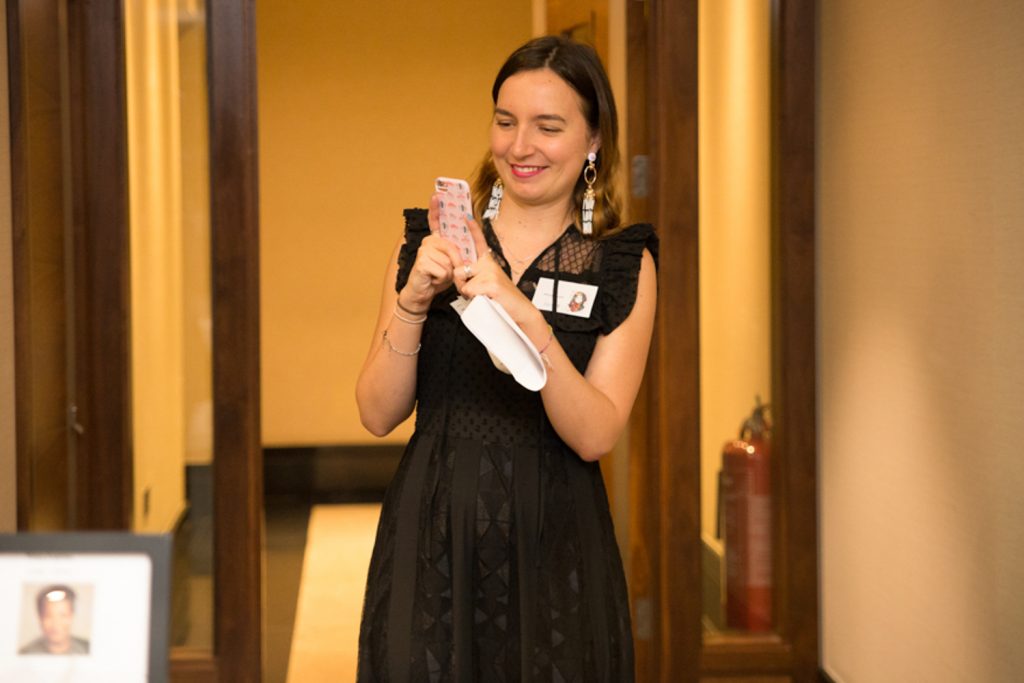 Nicely dressed lady at event looking at her phone