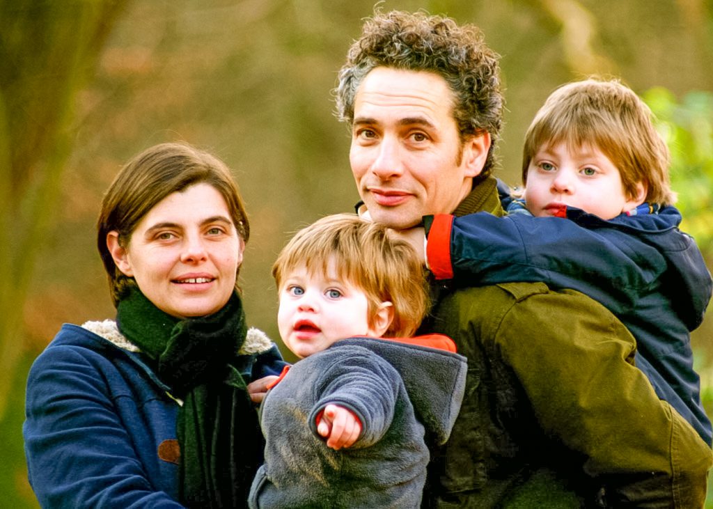 Family together in the woods. Parents holding up their two boys