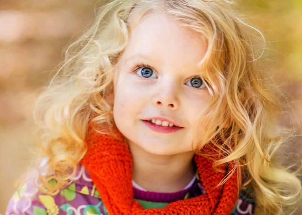 Little blonde girl staring upwards in the woods in North London
