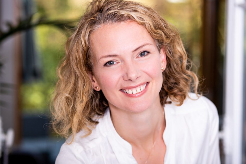 Smiling woman with blonde hair smiling into camera