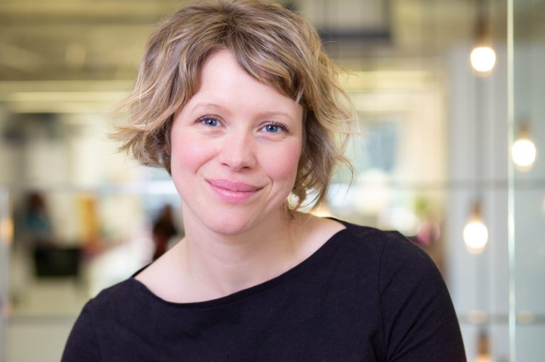 Smiling blonde woman with lights in the background
