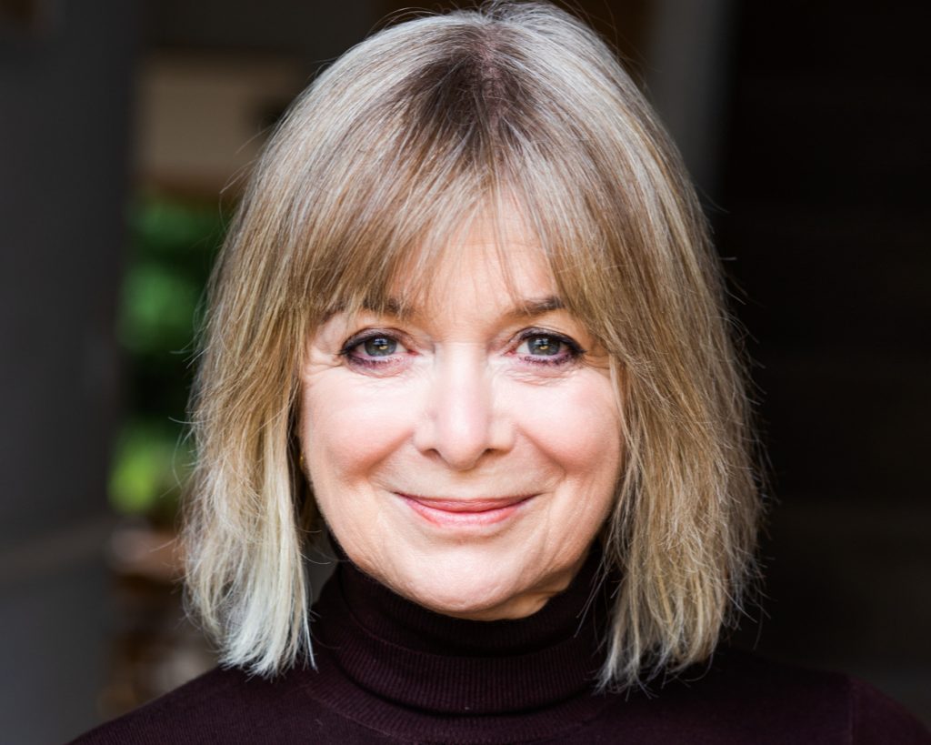Older actress with blonde hair smiling into camera