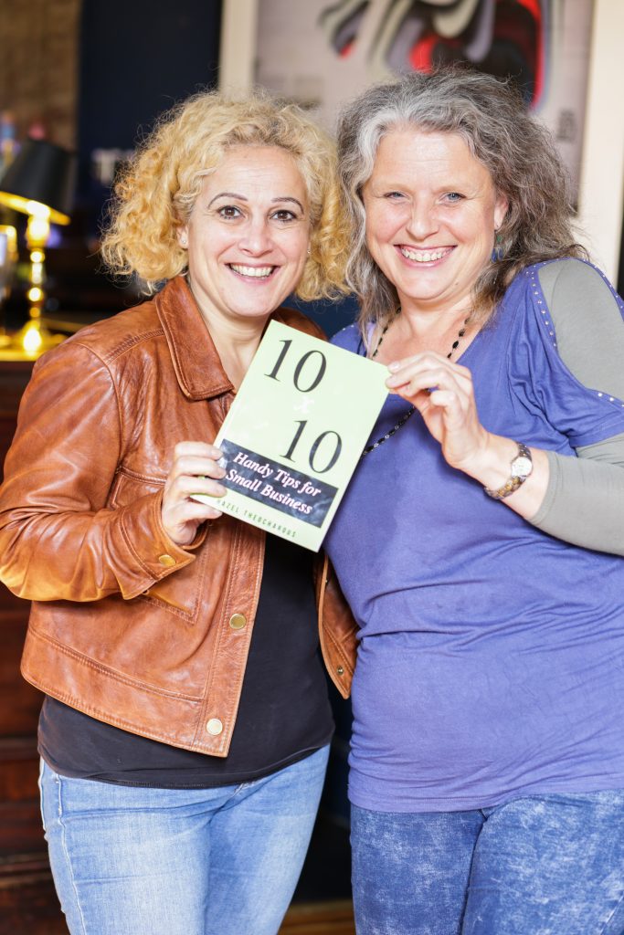 Two happy ladies holding a book