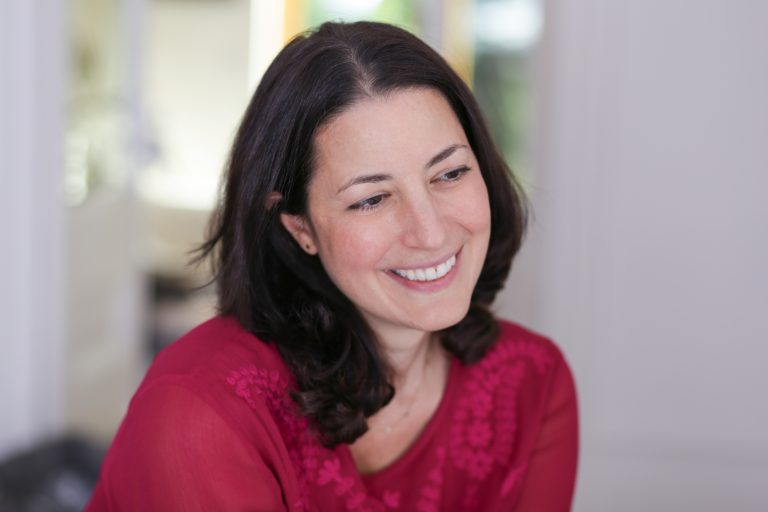 Smiling woman with black hair and red shirt