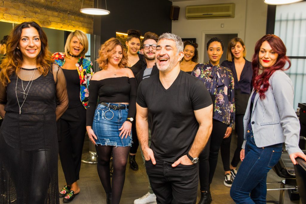group of hairdressers laughing and smiling in their hair salon