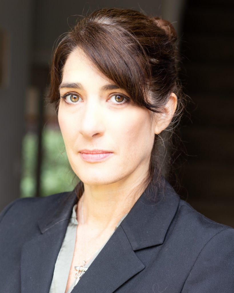 Actress with dark hair up in a bun