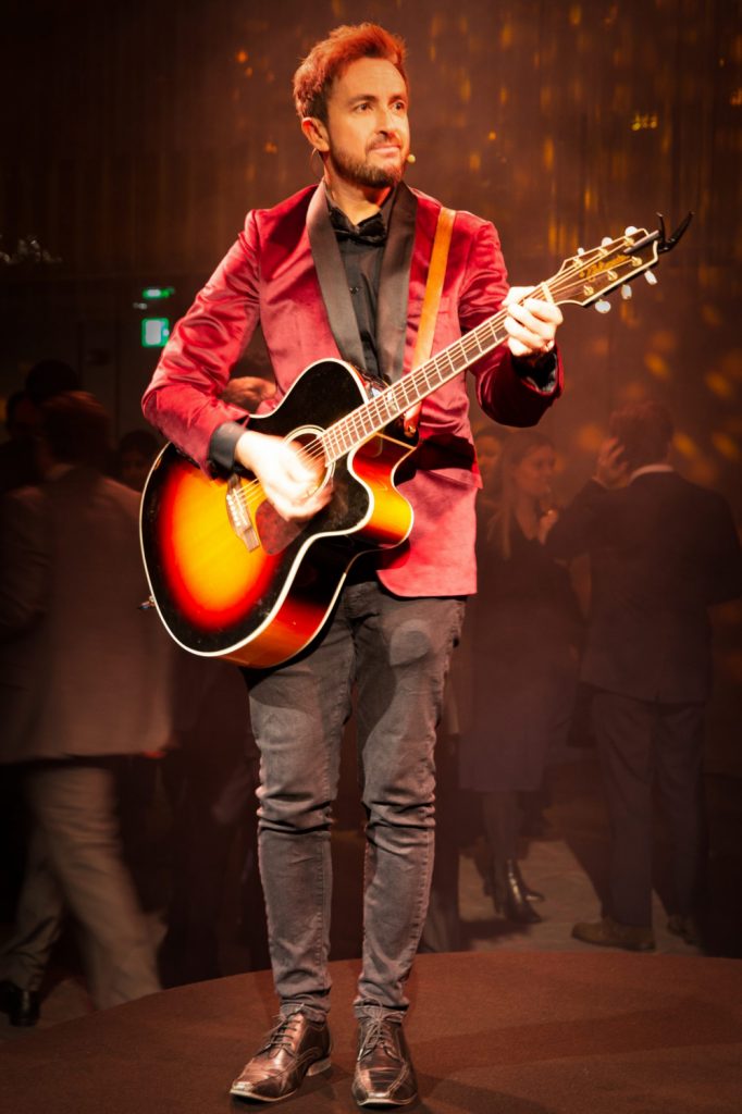 Red haired guitarist playing at a party