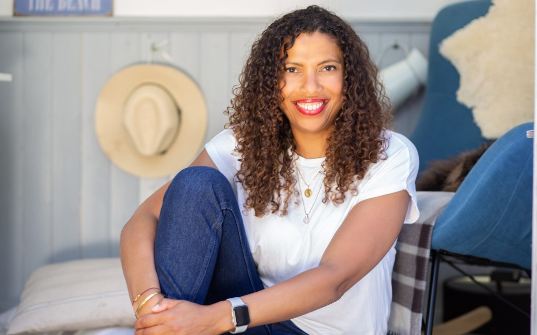 Headshot Photography in North London with Woman in tea shirt and jeans sitting in a beach hut
